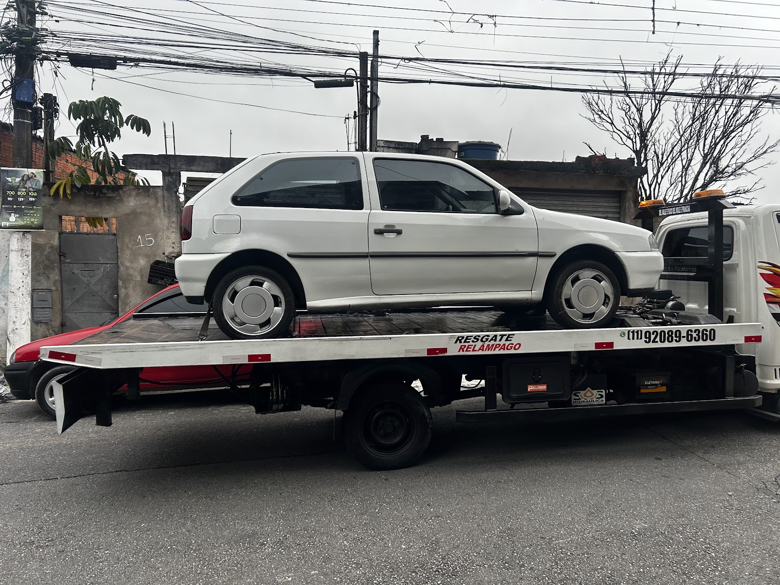 Foto real do GUINCHO RELÂMPAGO: carro branco transportado em plataforma de reboque em São Paulo